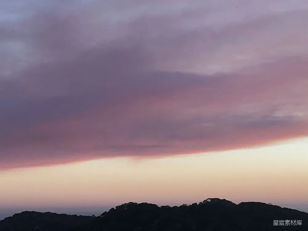 高清摄影  一架飞在空中的飞机，背景是山。