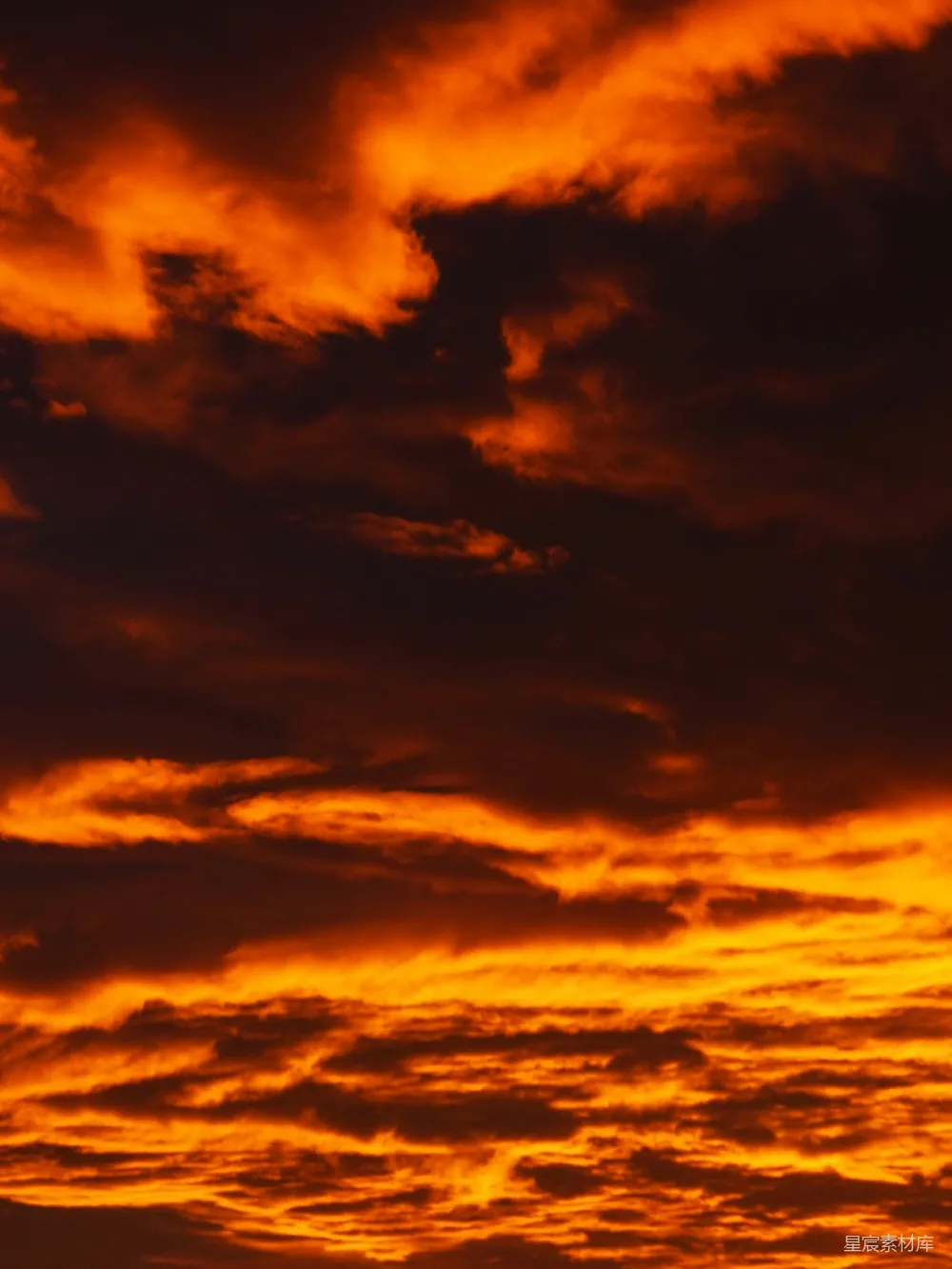 高清摄影  夕阳下，天空被戏剧性的橙色和红色云朵填满。