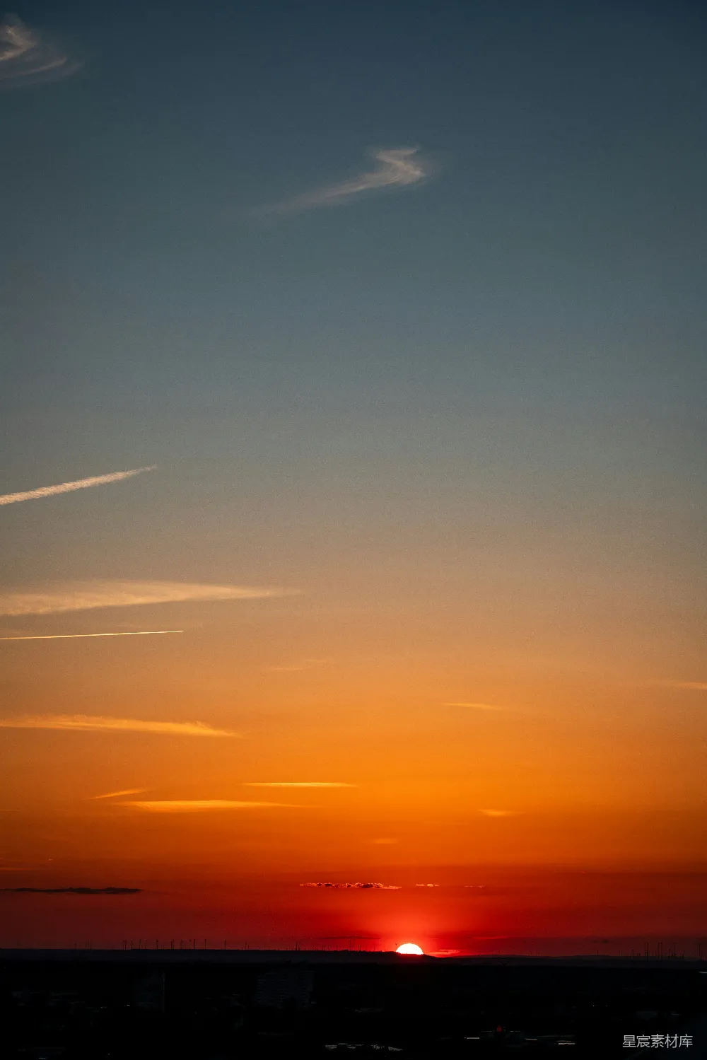 高清摄影  绚丽的橙色和红色夕阳笼罩在黑暗的地平线上。