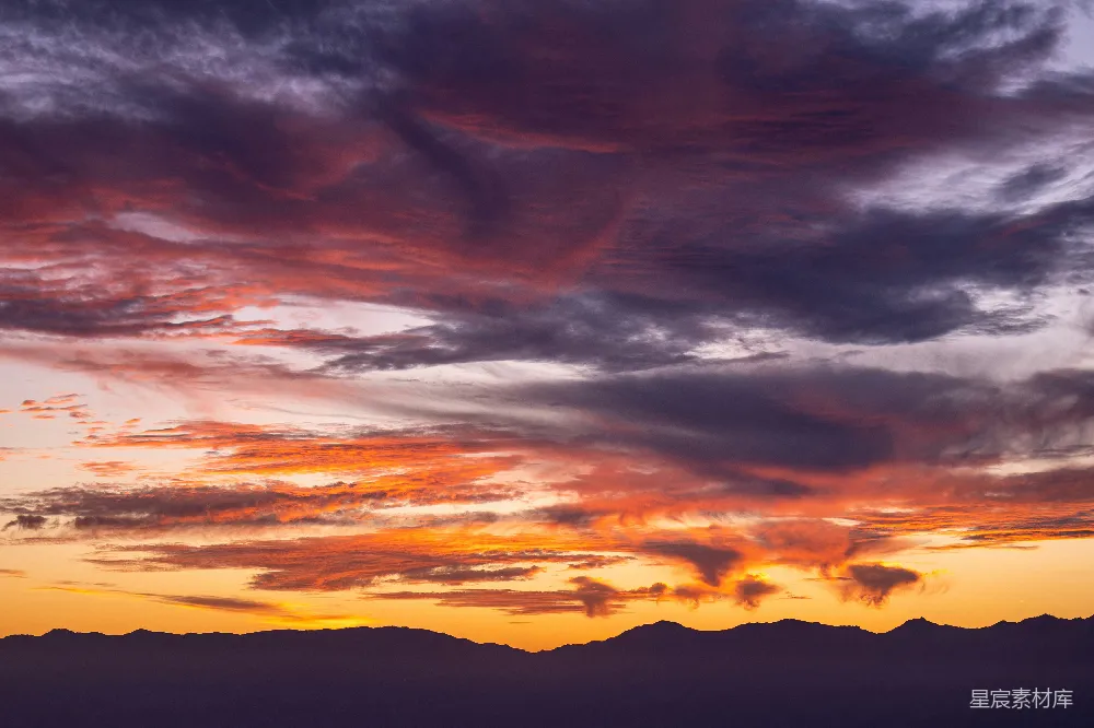 高清摄影  夕阳西下，云层和山脉在背景中。