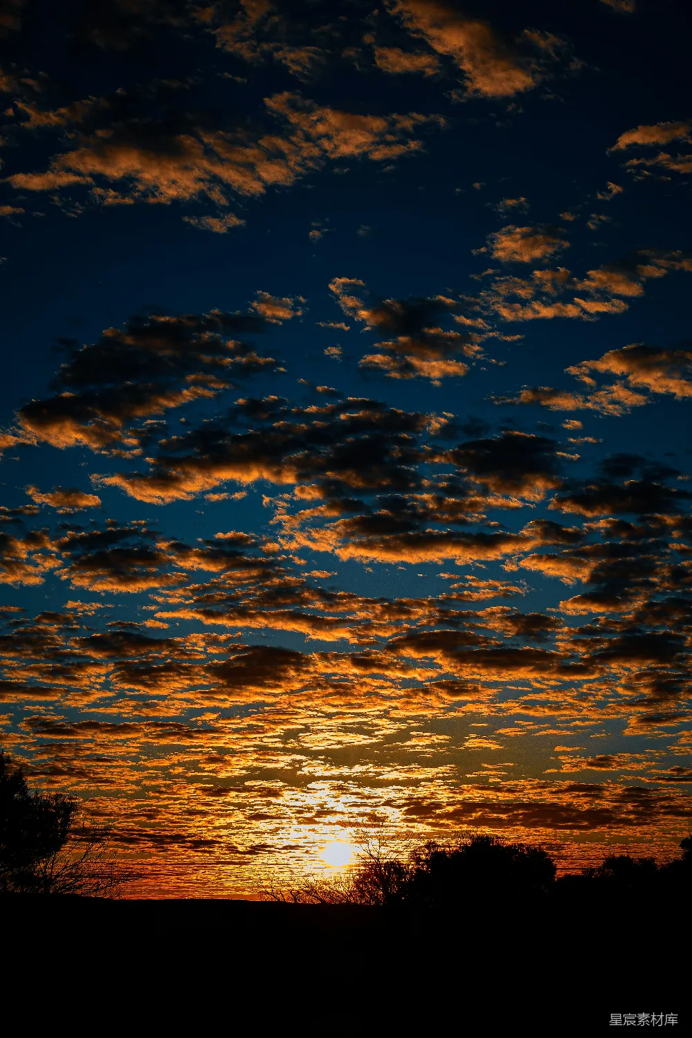 高清摄影  夕阳西下，火烧云映照在剪影般的地平线上。