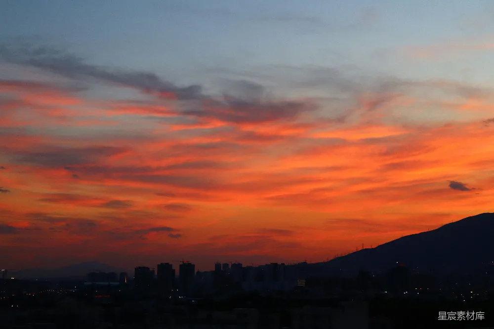 高清摄影  城市日落景色，背景中有座山。