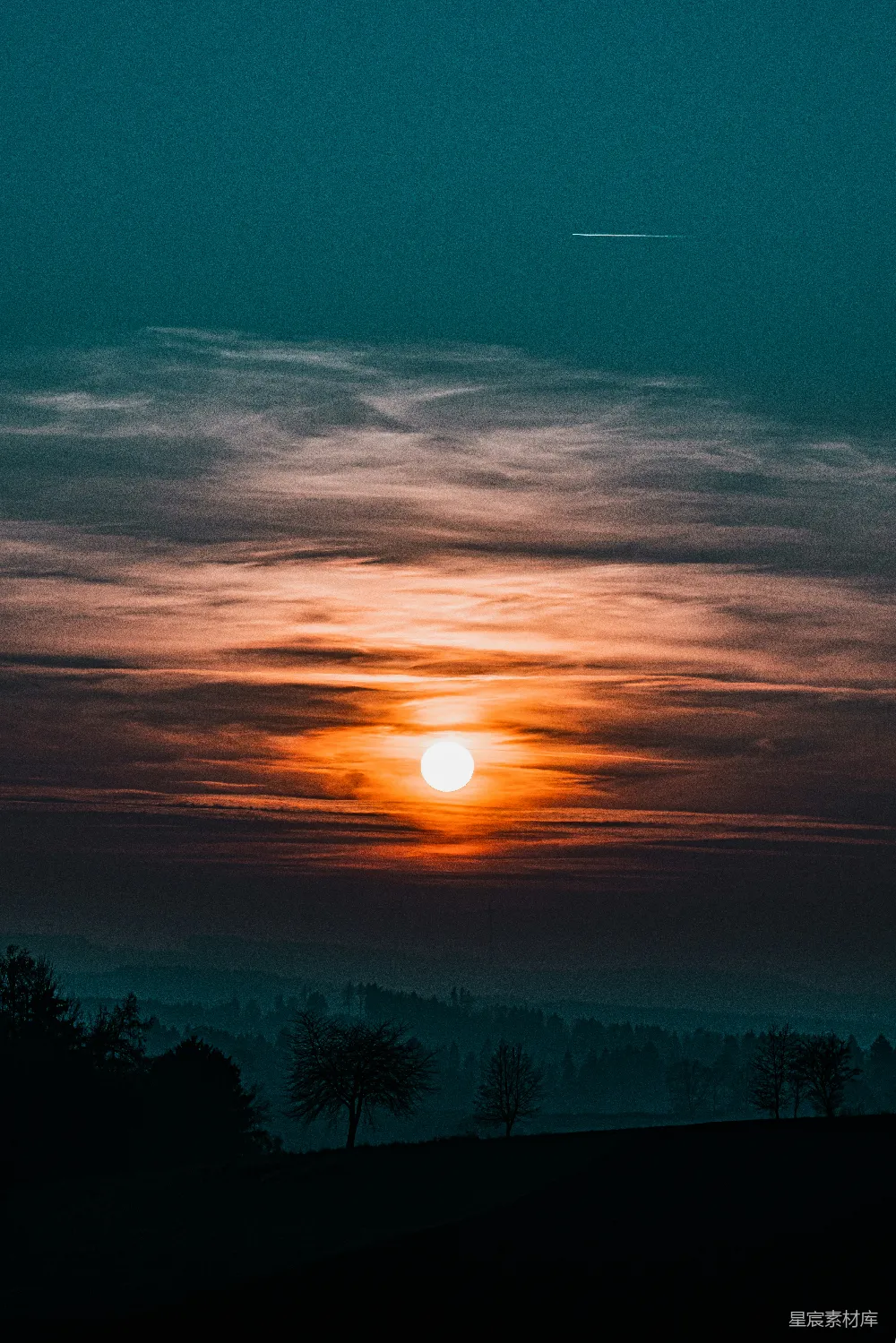 高清摄影  夕阳正挂在田野上方的天空中。