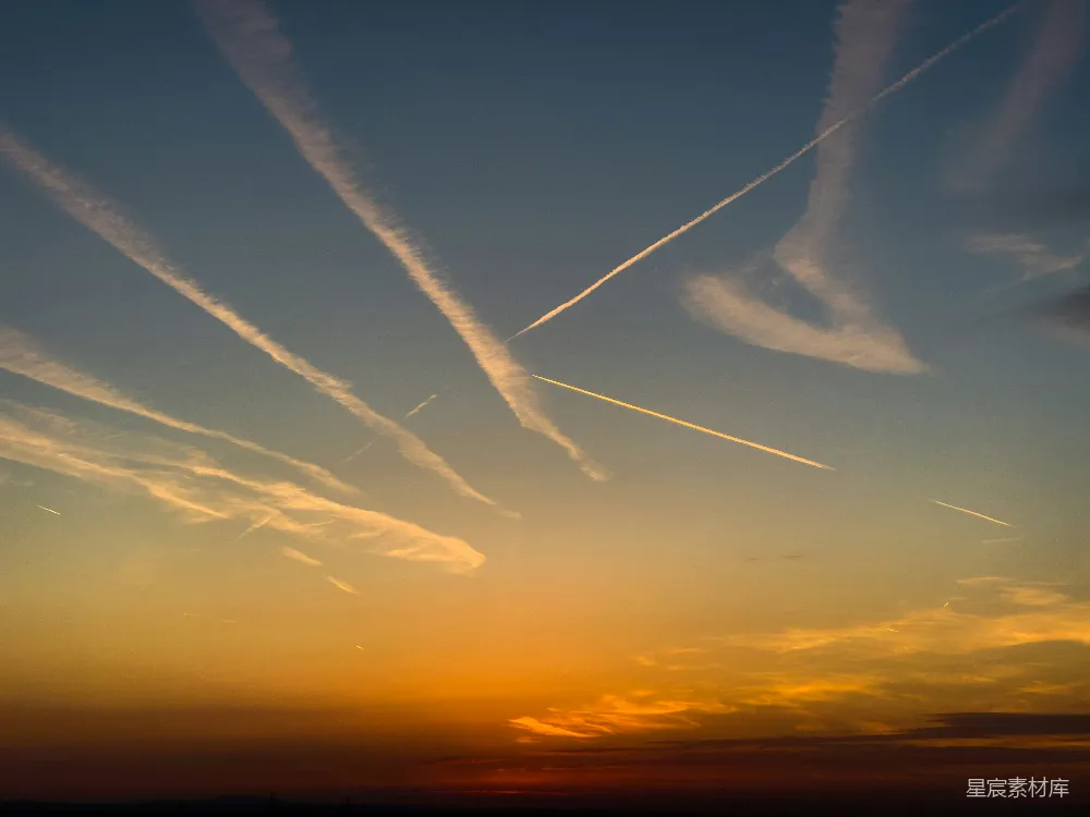 高清摄影  夕阳西下，空中有飞机的航迹云。