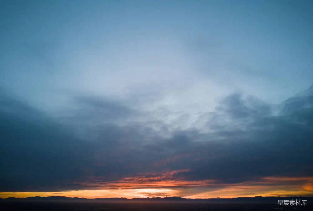 高清摄影  夕阳的天际线上，橙色的余晖下飘着乌云。