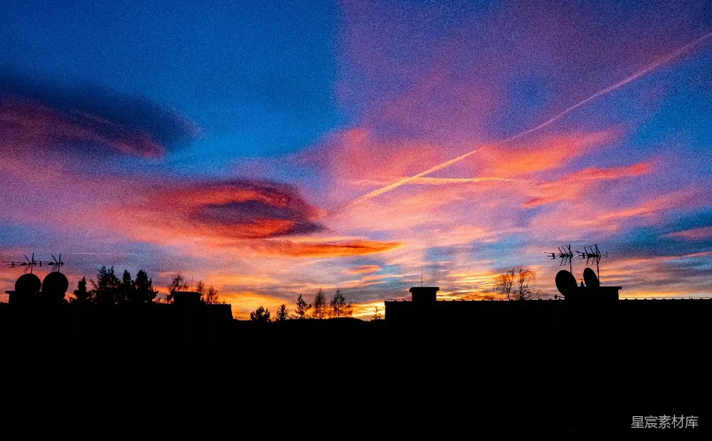 高清摄影  绚丽的夕阳天空笼罩着剪影般的屋顶。