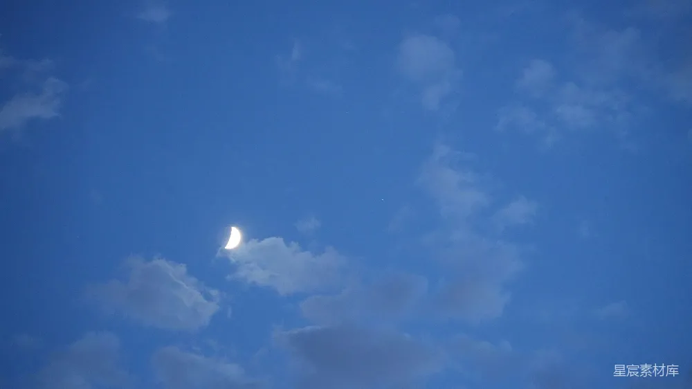 高清摄影  在蓝色的天空中，能看到一轮弯月。