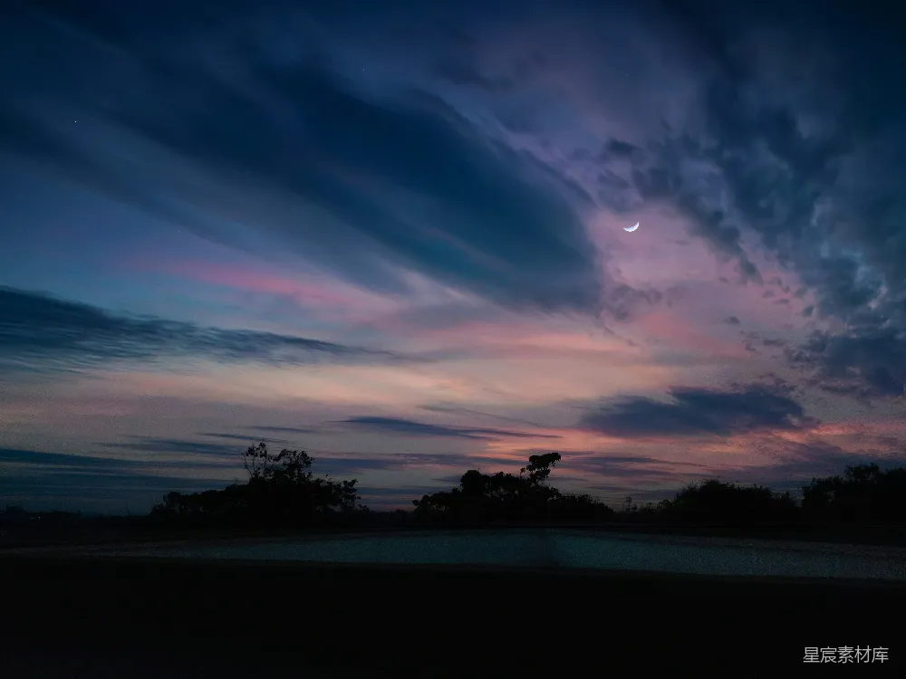 高清摄影  夜晚的天空，云层缭绕，远处有月亮。