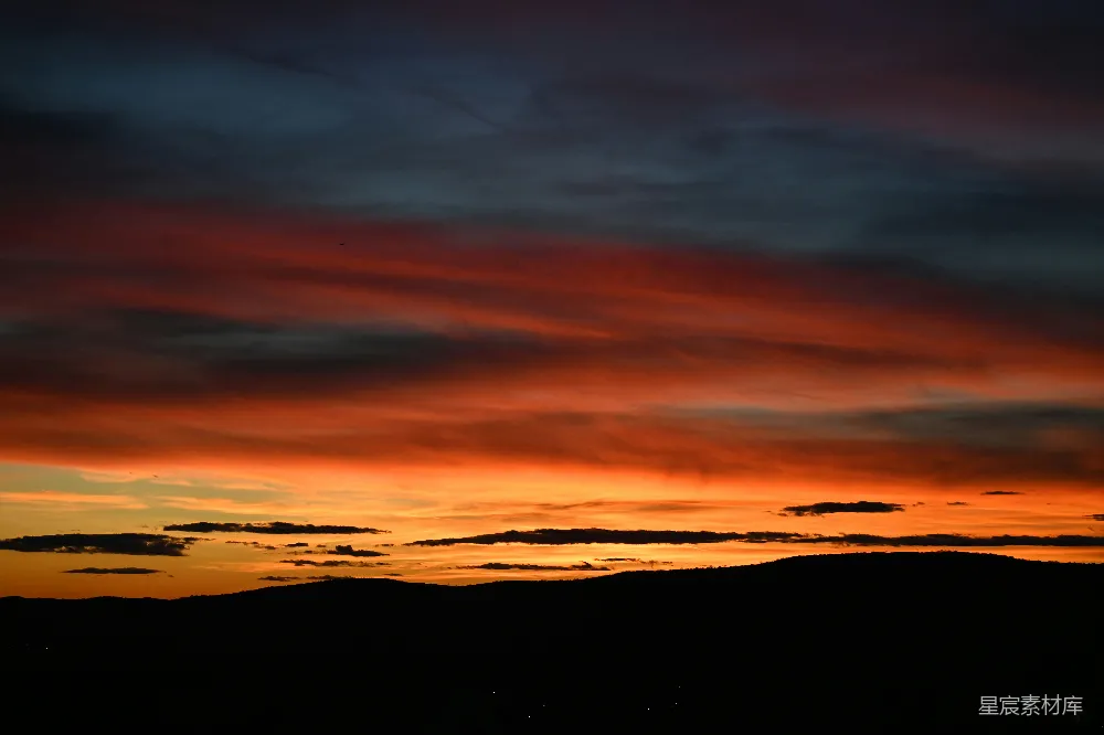 高清摄影  色彩斑斓的夕阳天空，山脚下是轮廓分明的山峦。