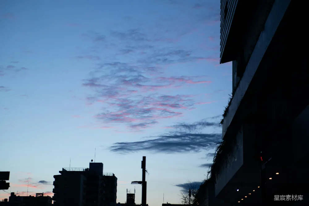 高清摄影  黄昏时分的城市街道，天空中有几朵云。