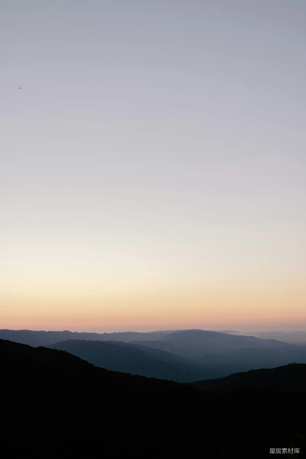 高清摄影  一个人站在山顶上，夕阳西下。