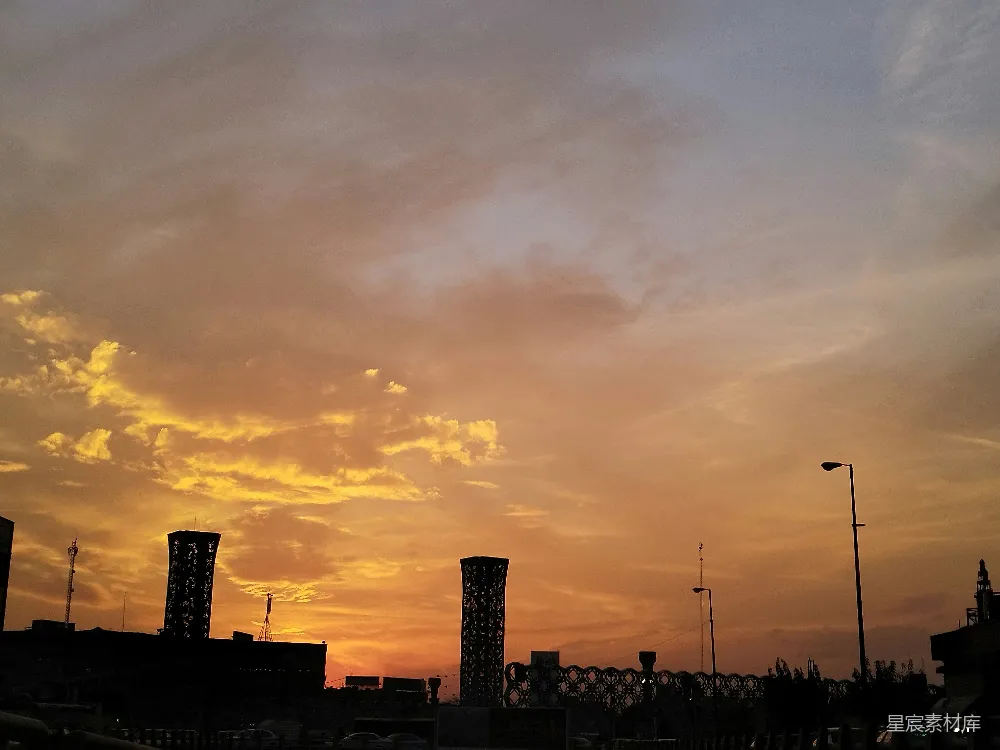 高清摄影  夕阳正挂在高楼大厦间的城市上空。