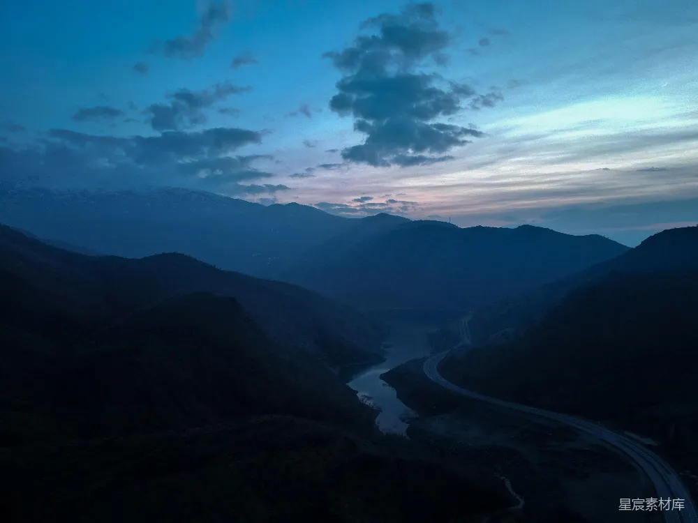 高清摄影  一条河流穿过山谷，山峦环绕。