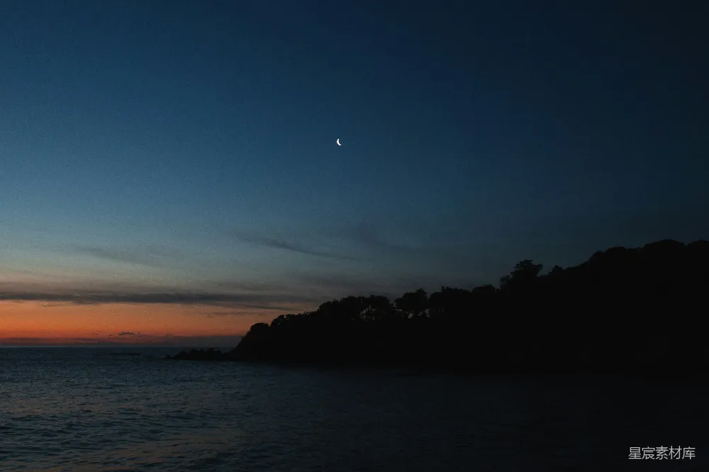 高清摄影  夕阳正缓缓落下，海面上有一座小岛隐约可见。