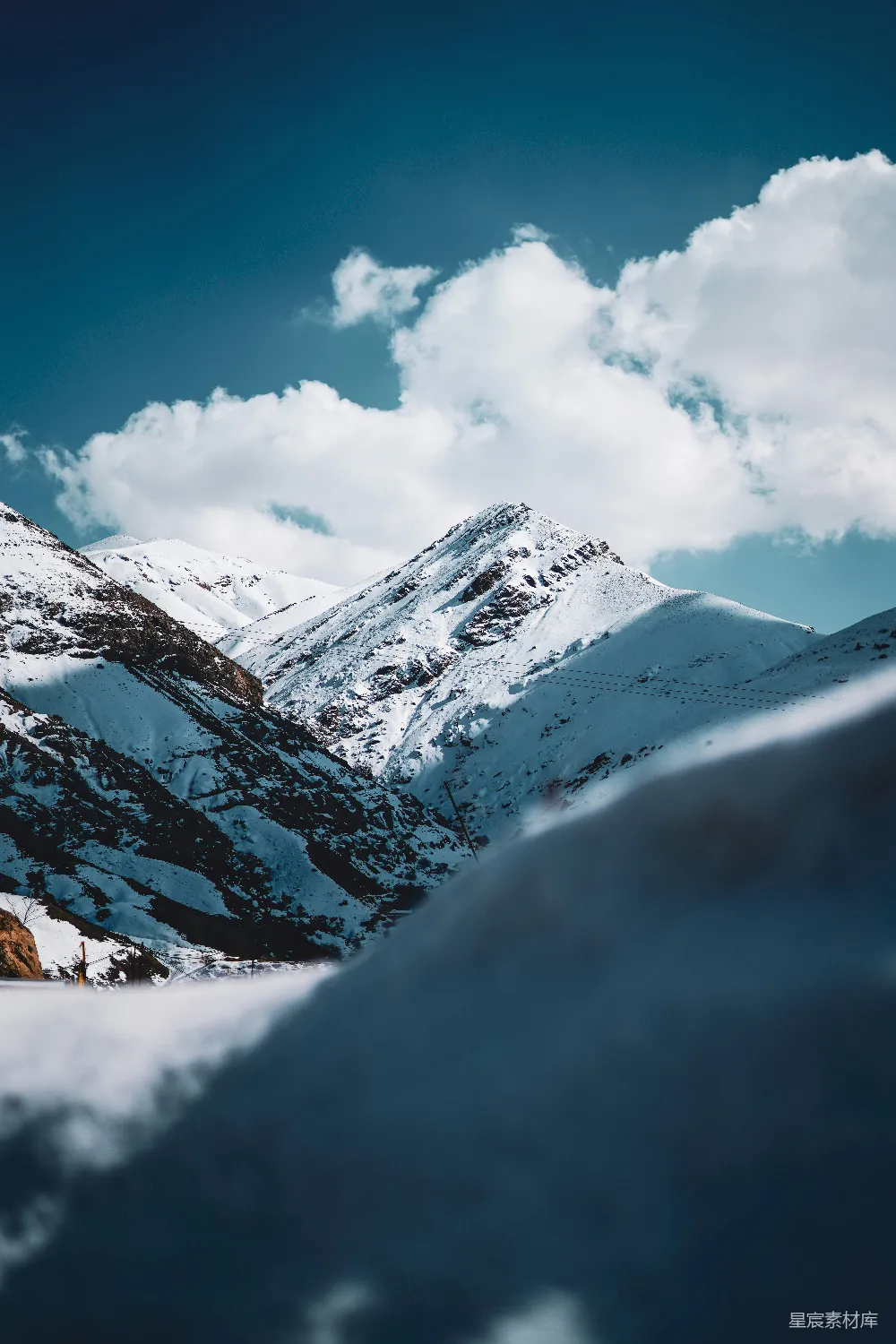 高清摄影 旅行 自然 壁纸 一座覆盖着积雪的山脉在阴云密布的蓝天之下