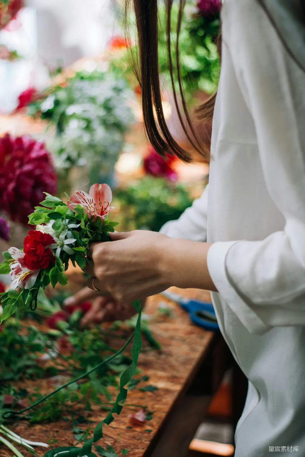 高清摄影  一位女士在花店整理花束。