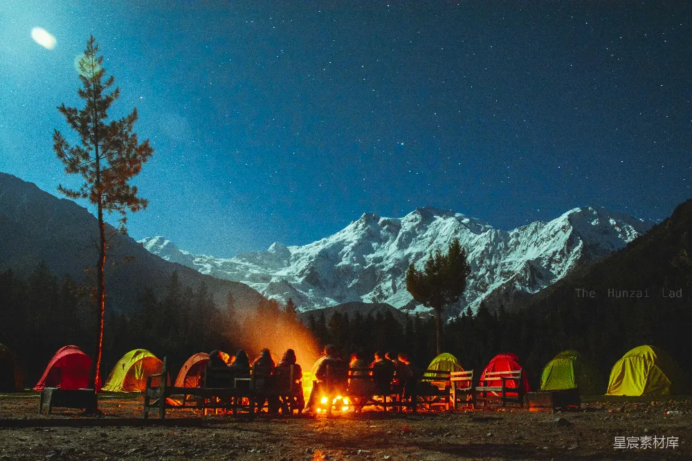 高清摄影  星空下的露营，有篝火、帐篷和雪山。