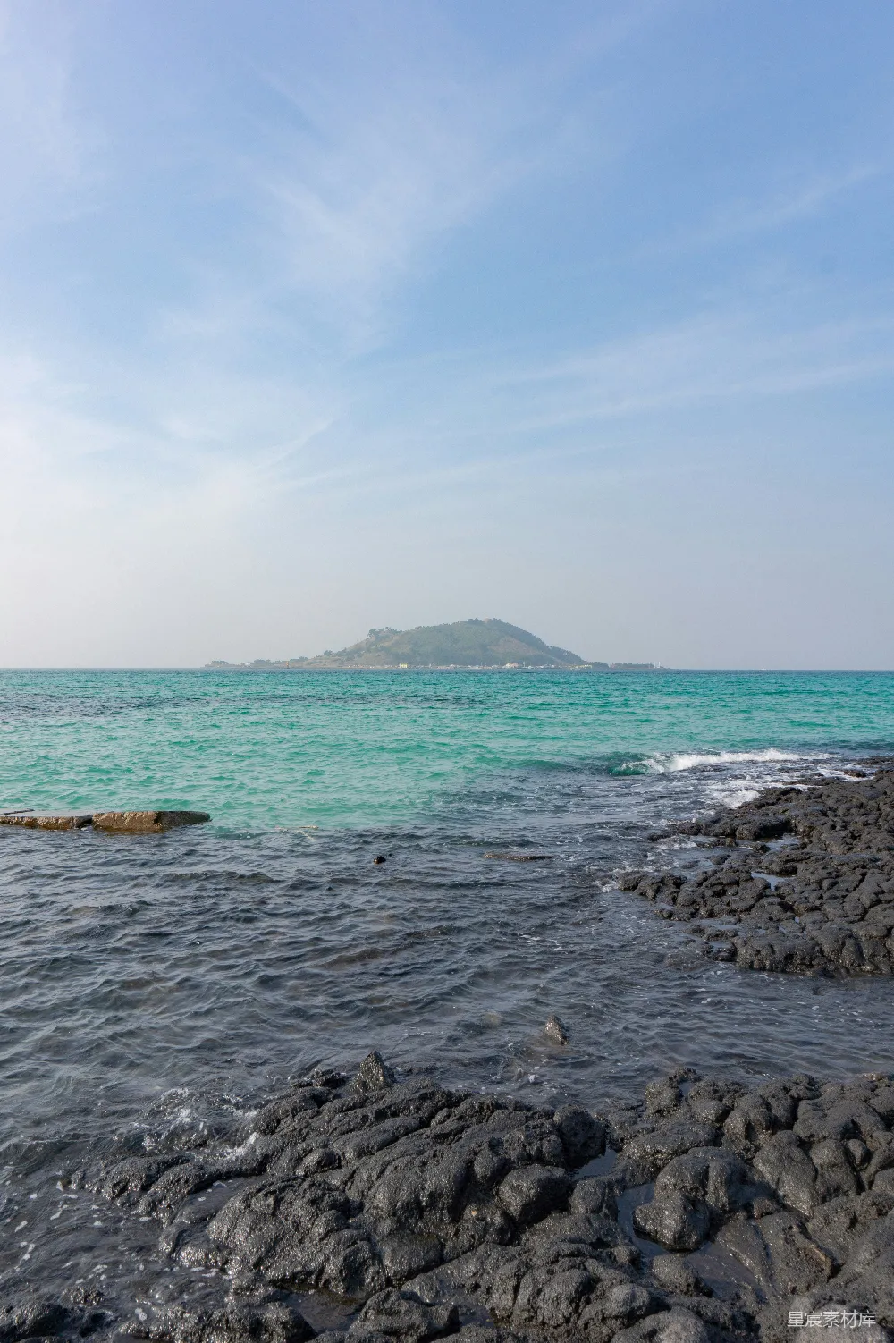 高清摄影  一个岩石海滩，远处有一座大岛。