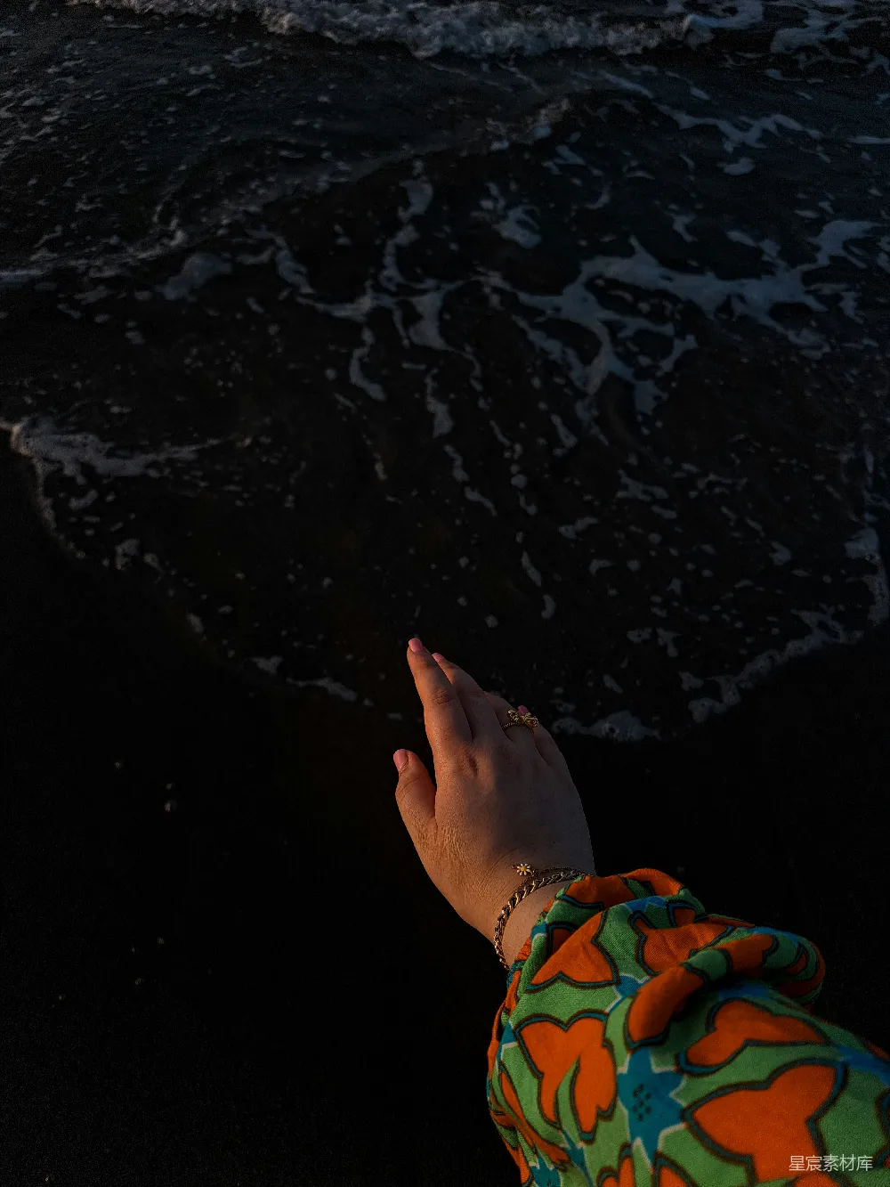 高清摄影  手和手臂伸向黑暗的海浪。