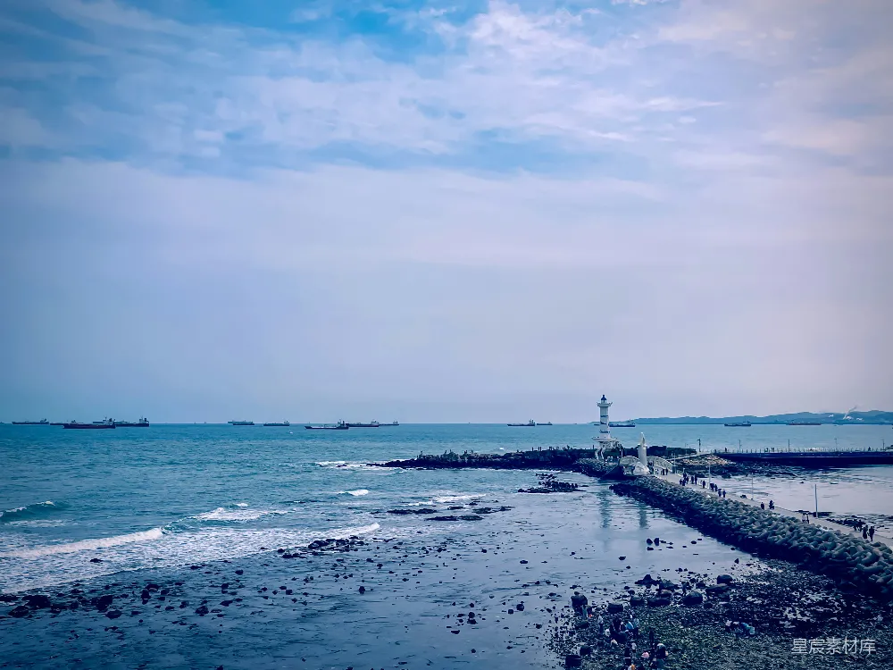 高清摄影  一片水域，远处有一座灯塔。