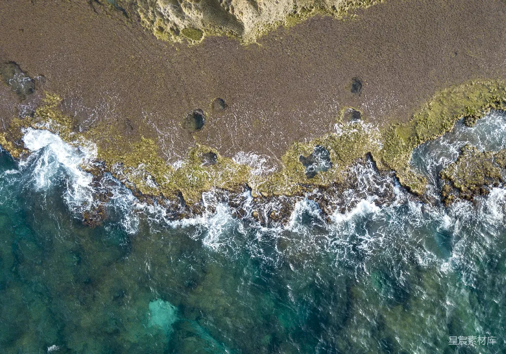 高清摄影  海滩上的鸟瞰图，海浪拍打着沙滩。