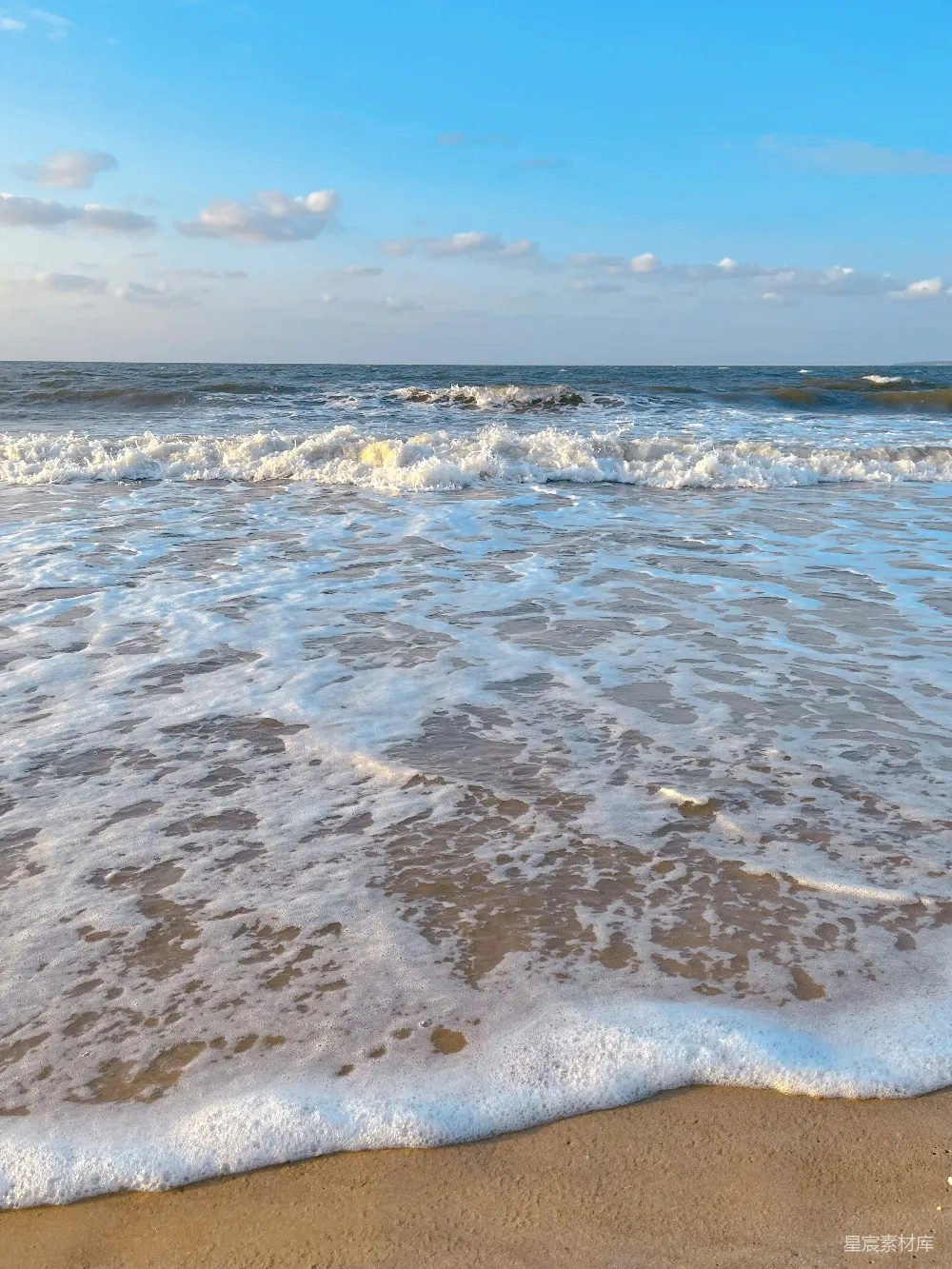 高清摄影  一个沙滩上，海浪拍打着岸边。