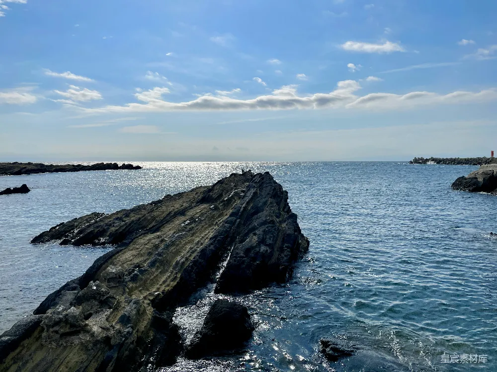 高清摄影  一个岩石海滩，背景中有一片水域。