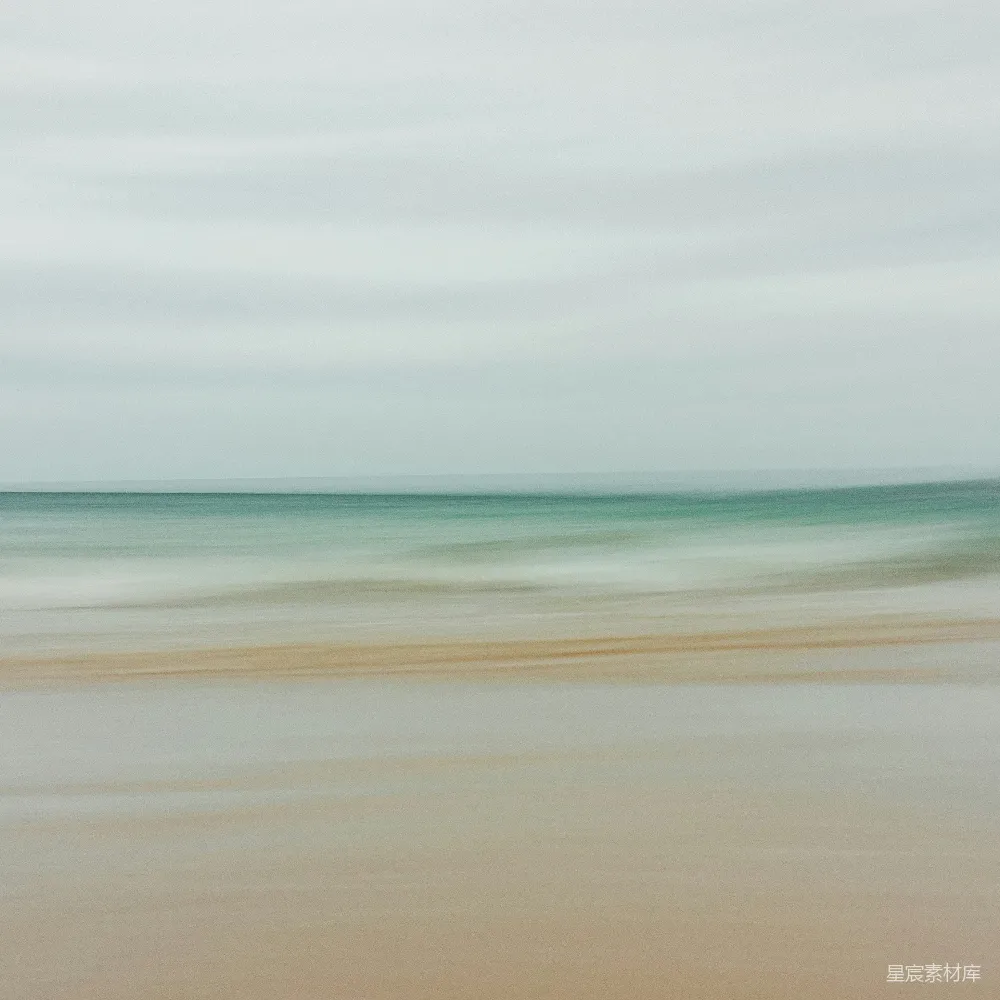 高清摄影  一张模糊的海滩照片，海浪拍打着岸边。