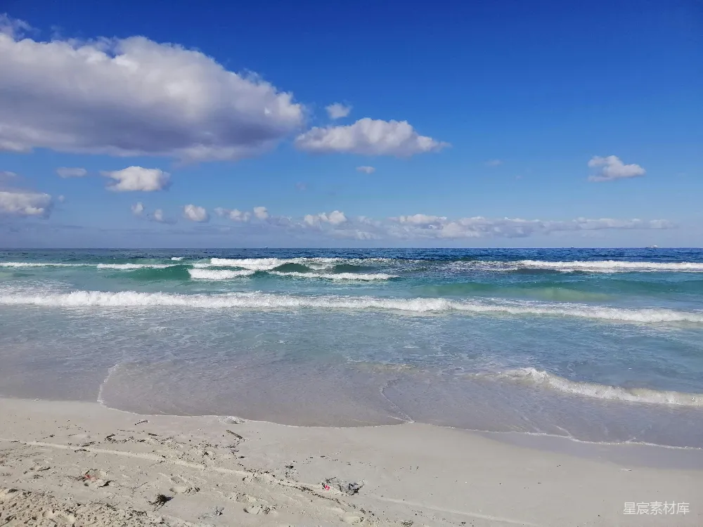 高清摄影  白天，蓝天白云下，海浪拍打着海岸。