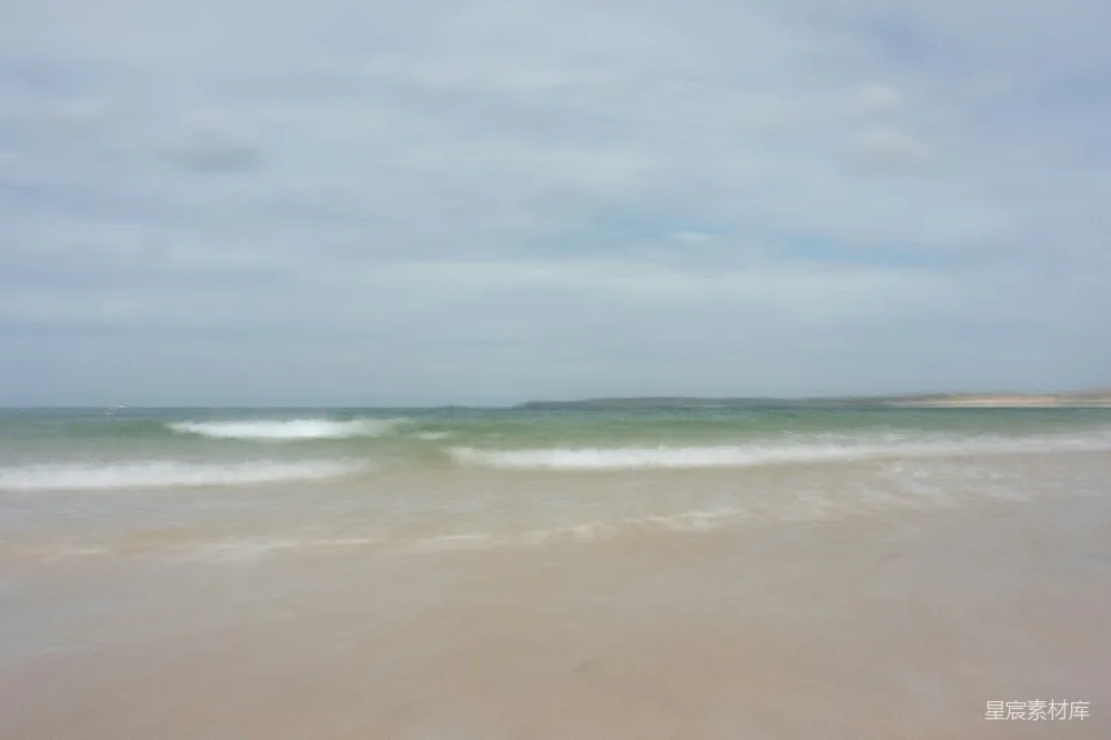 高清摄影  模糊的海滩照片，海浪正冲向岸边。