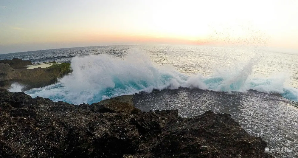 高清摄影  白天，海浪拍打着黑色岩石形成的地貌。