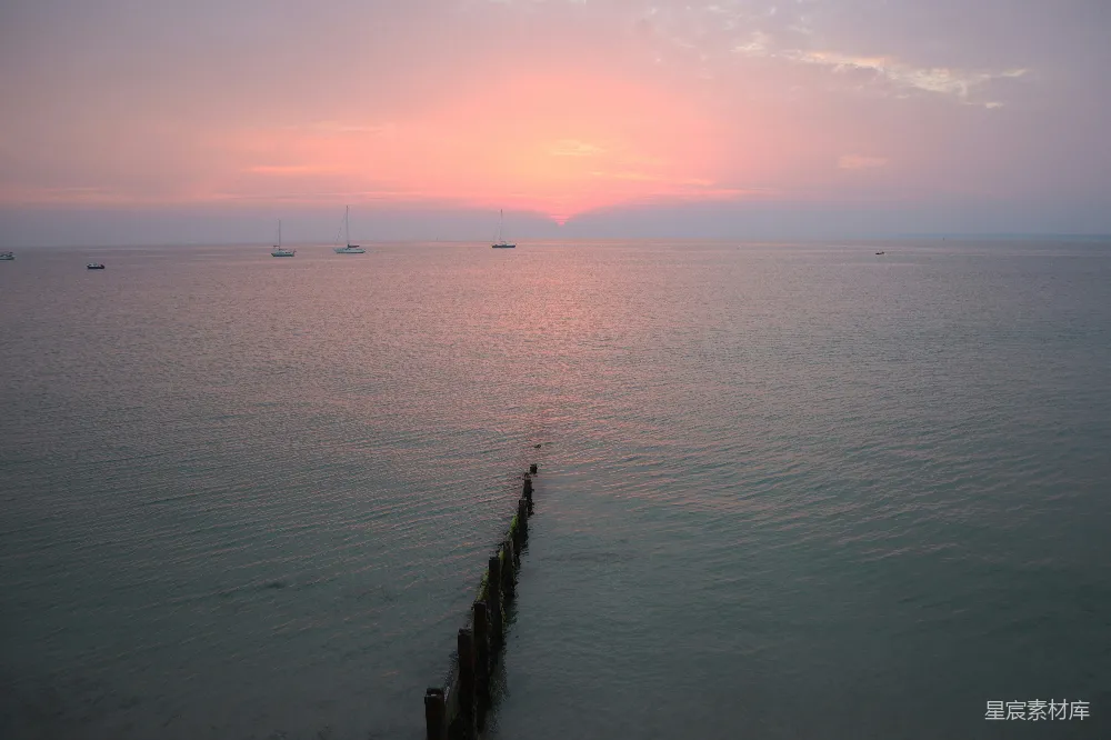 高清摄影  海面上的棕色木制码头在夕阳下