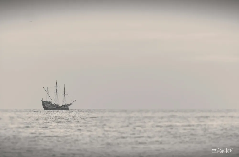 高清摄影  白天，白天空中，黑船在海上漂浮。