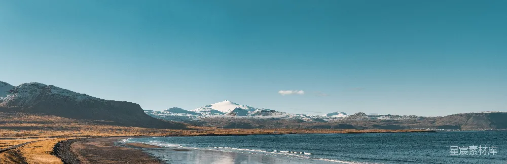 高清摄影  一片海滩的景色，背景是连绵的山脉。