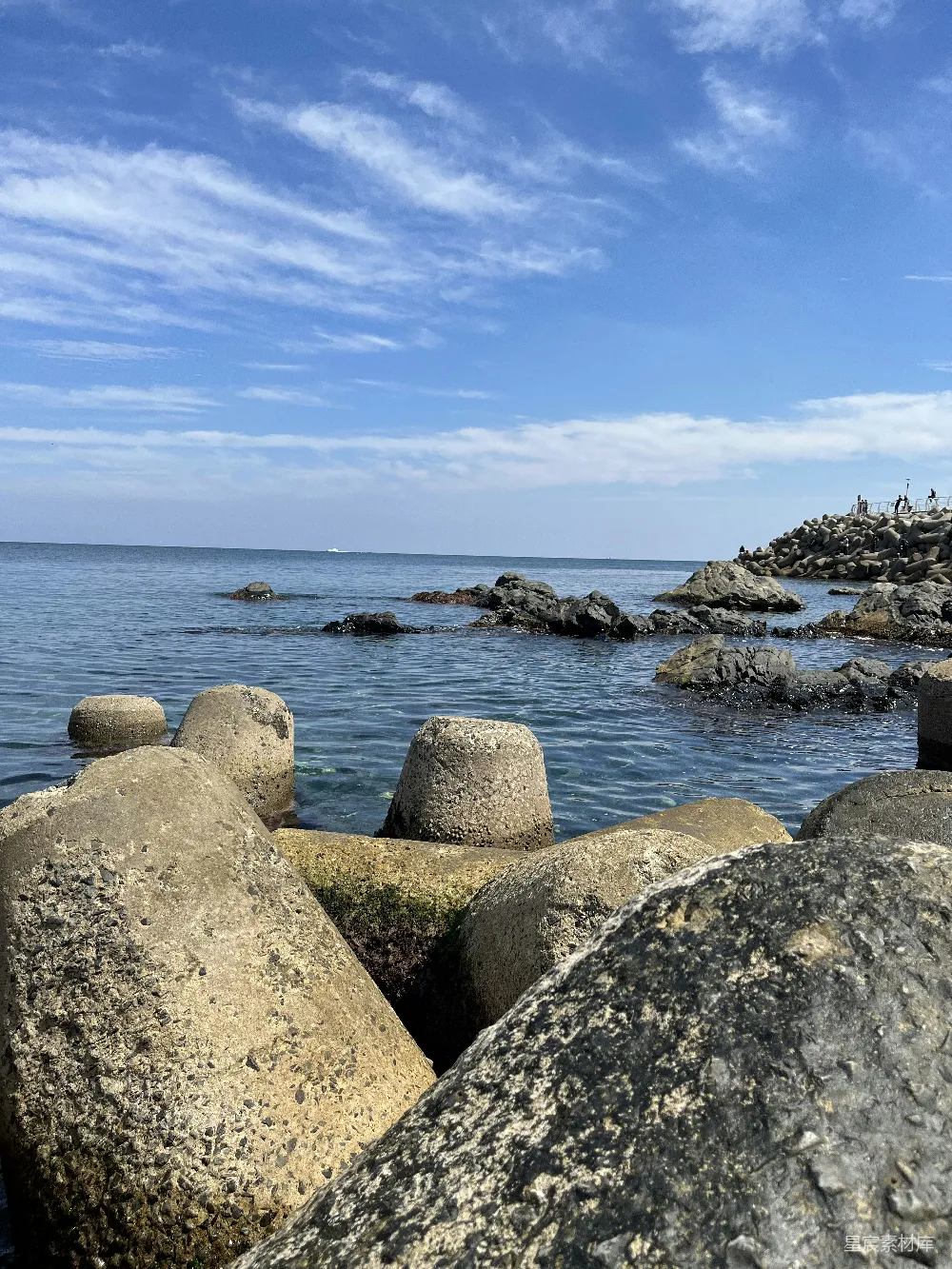 高清摄影  一个岩石海滩，背景中有一片水域。