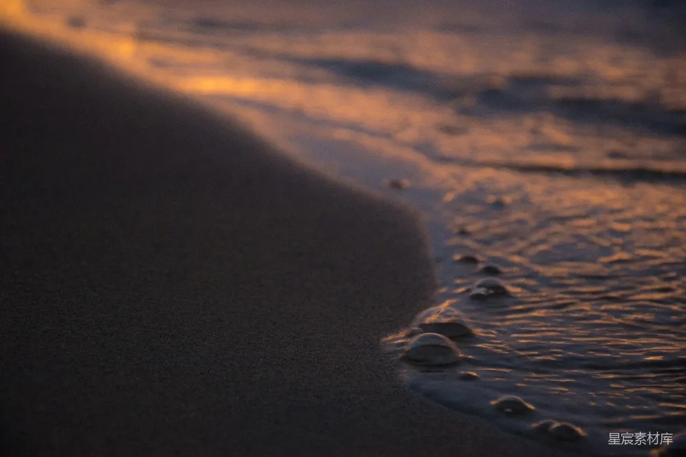高清摄影  夕阳下，温柔的海浪轻拂着沙滩。