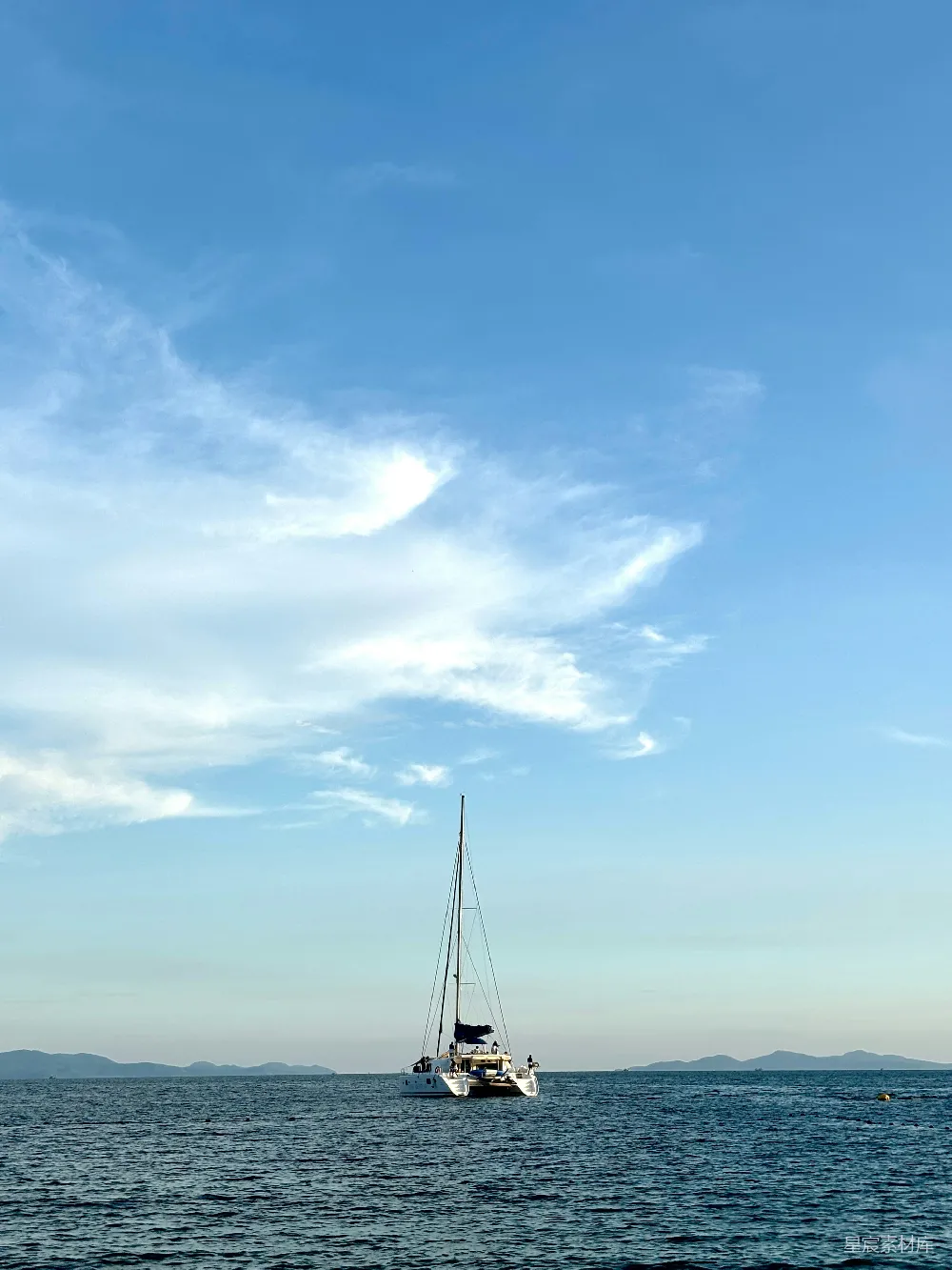 高清摄影  一艘帆船在阳光明媚的海面上飘浮。