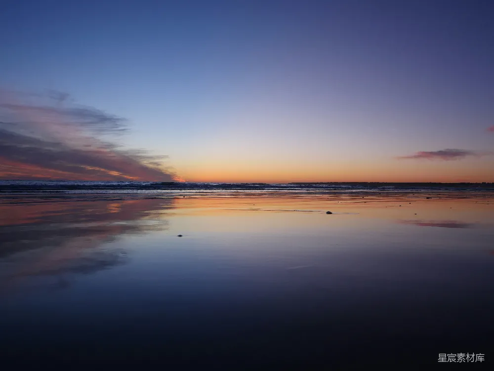 高清摄影  夕阳正缓缓落下，洒落在海面上，天空的颜色倒映在波光粼粼的水面上。