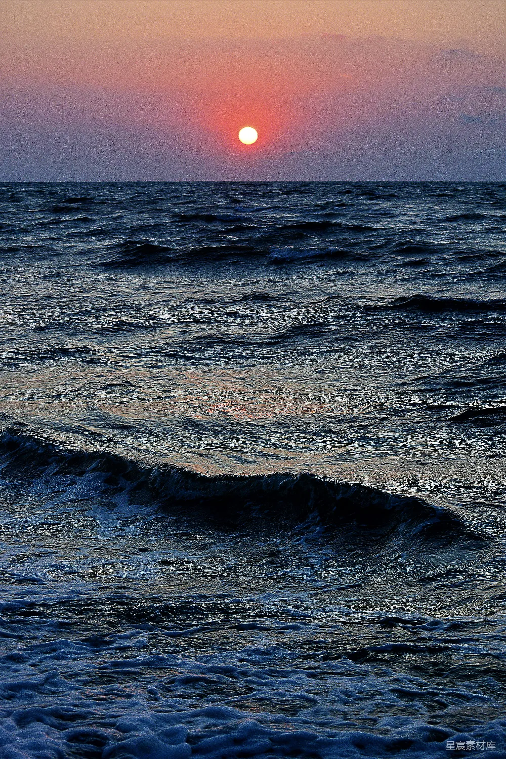 高清摄影  一片带有波浪和日落背景的水域。
