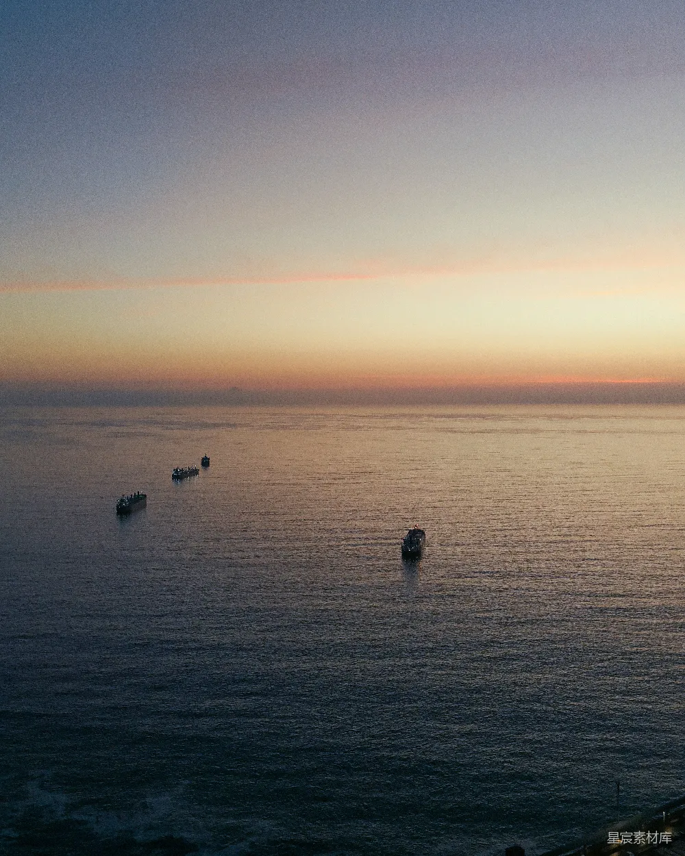 高清摄影  夕阳下的海洋上有几艘船。