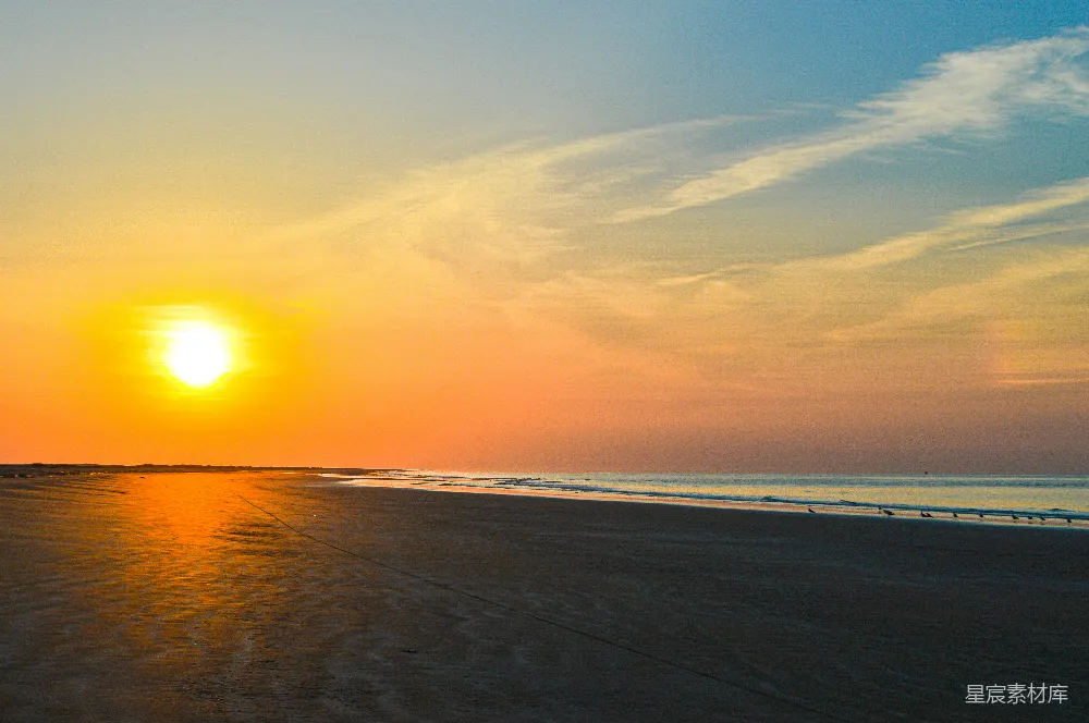 高清摄影  夕阳西下，海滩上，大海在背景中。
