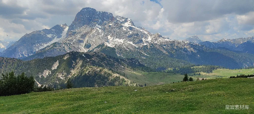 高清摄影  一片草地上有一座山在背景中