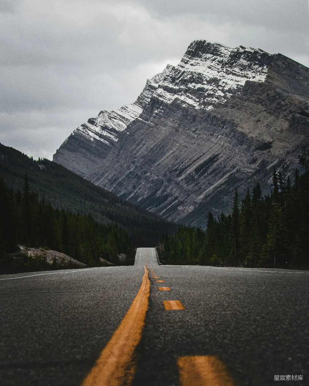 高清摄影  一条空旷的路，背景是一座山。