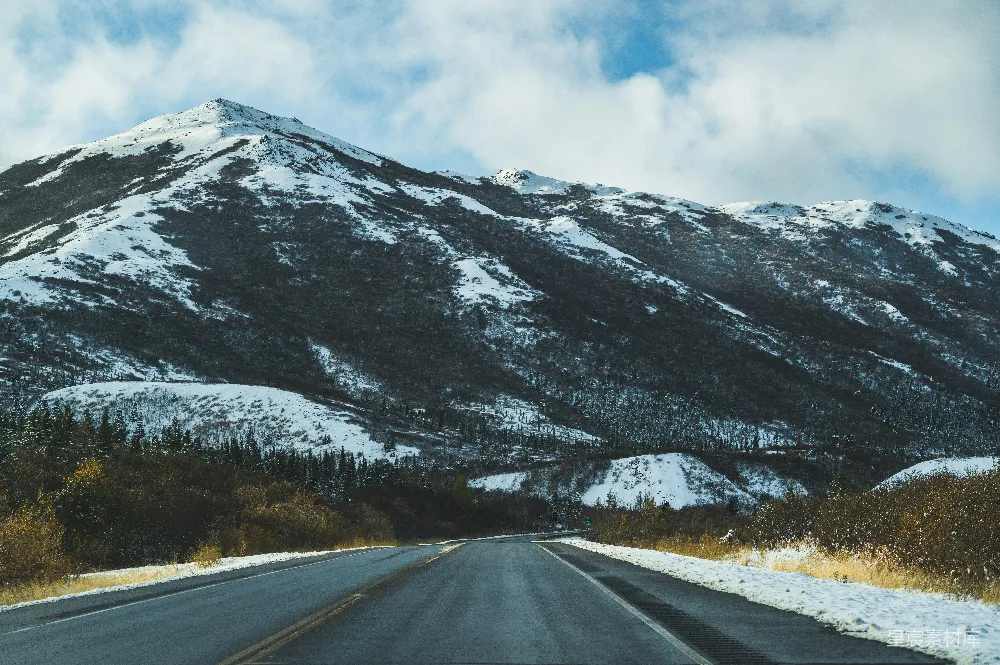 高清摄影  一座覆盖着积雪的山脉，一条道路穿过其中。
