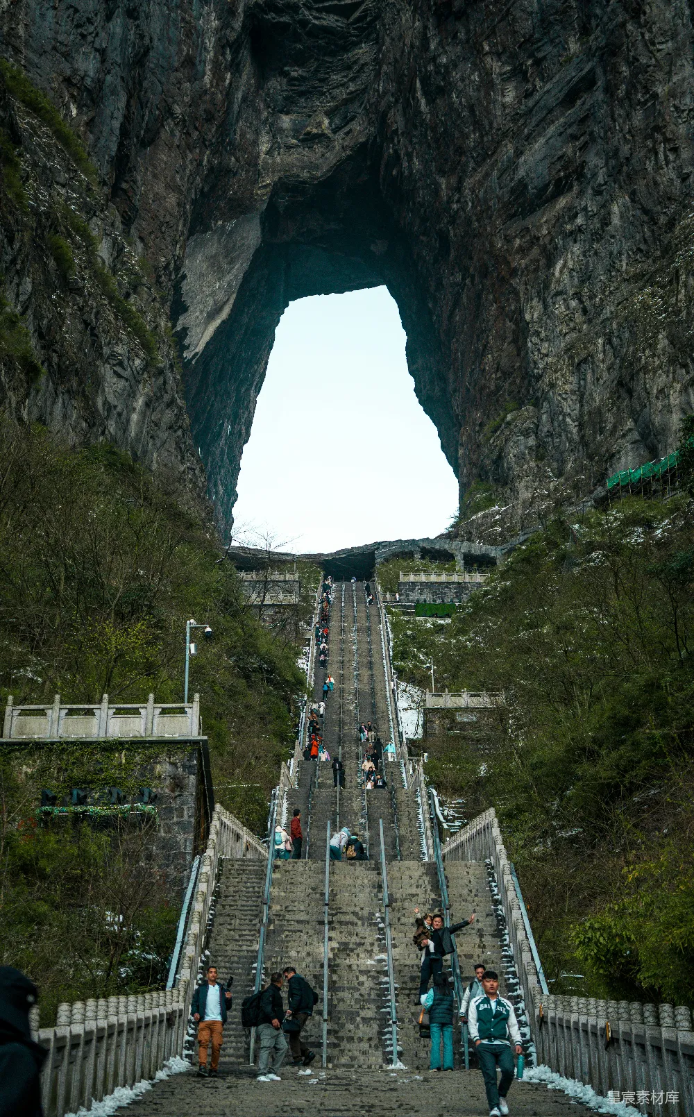 高清摄影 旅行 自然 人们沿着长长的楼梯走向一座岩石拱门。