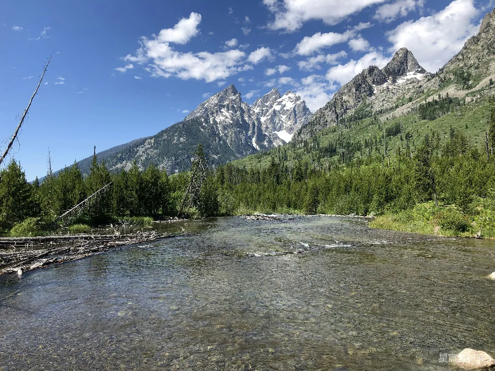 高清摄影  一条河，背景中有树木和山脉。