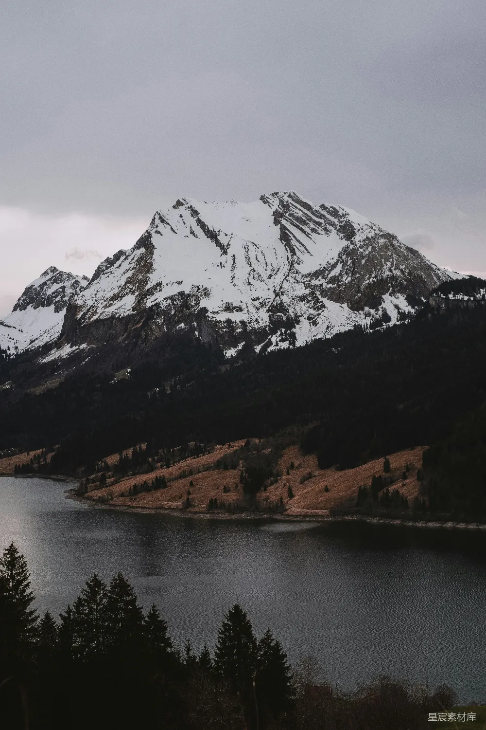 高清摄影  一座覆盖着雪的山，前景中有一片湖泊。