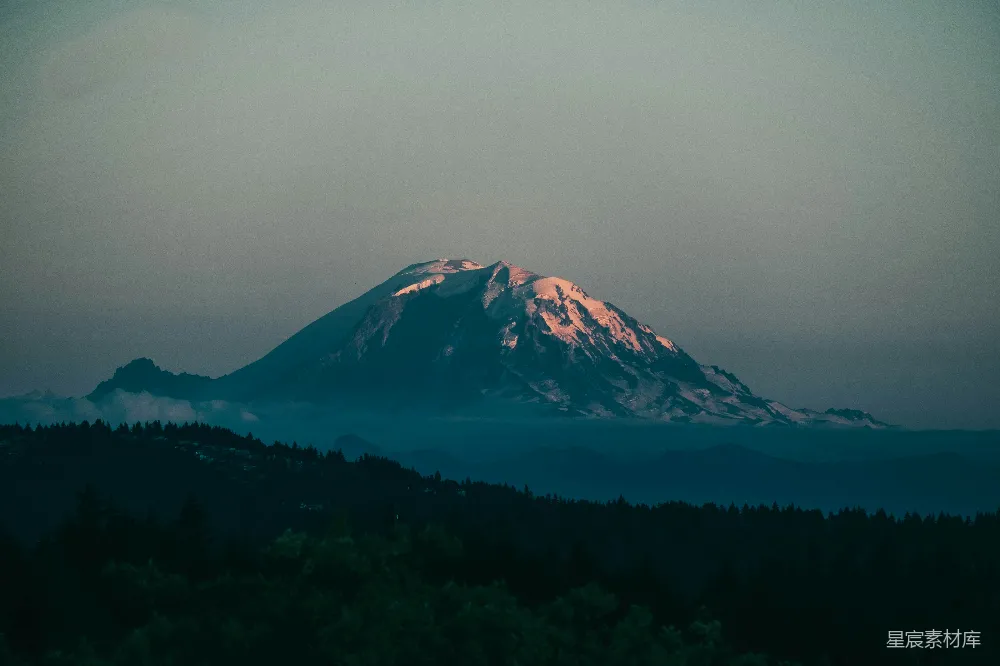 高清摄影  一座雪山，山脚下有树木。