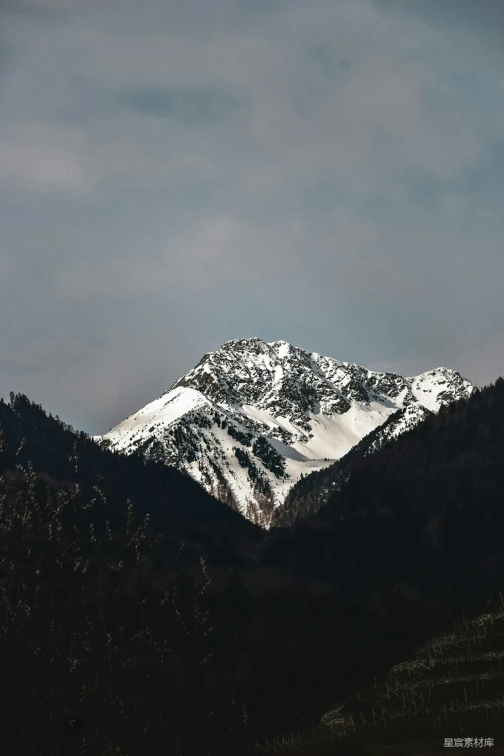 高清摄影  一座被雪覆盖的山在阴云密布的天空下