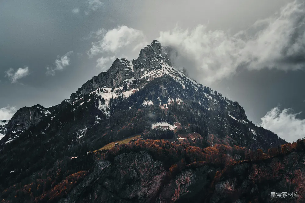 高清摄影  一座雄伟的山峰在暴风雨的云层下矗立。